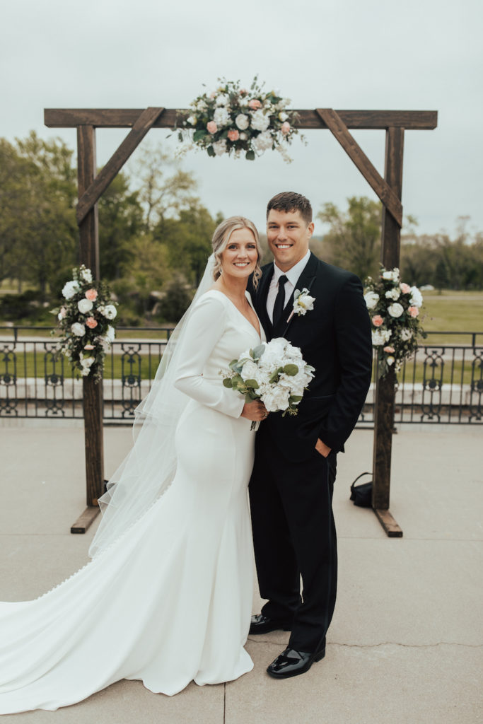 Elegant bride and groom first-look in front of their wedding arch at the Dousman House in Prairie du Chien, WI.