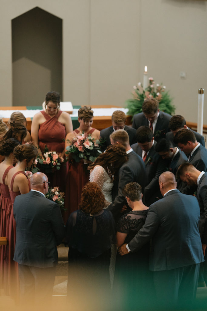 Intimate prayer after a wedding ceremony at the St. Paul Lutheran Church in Iowa.