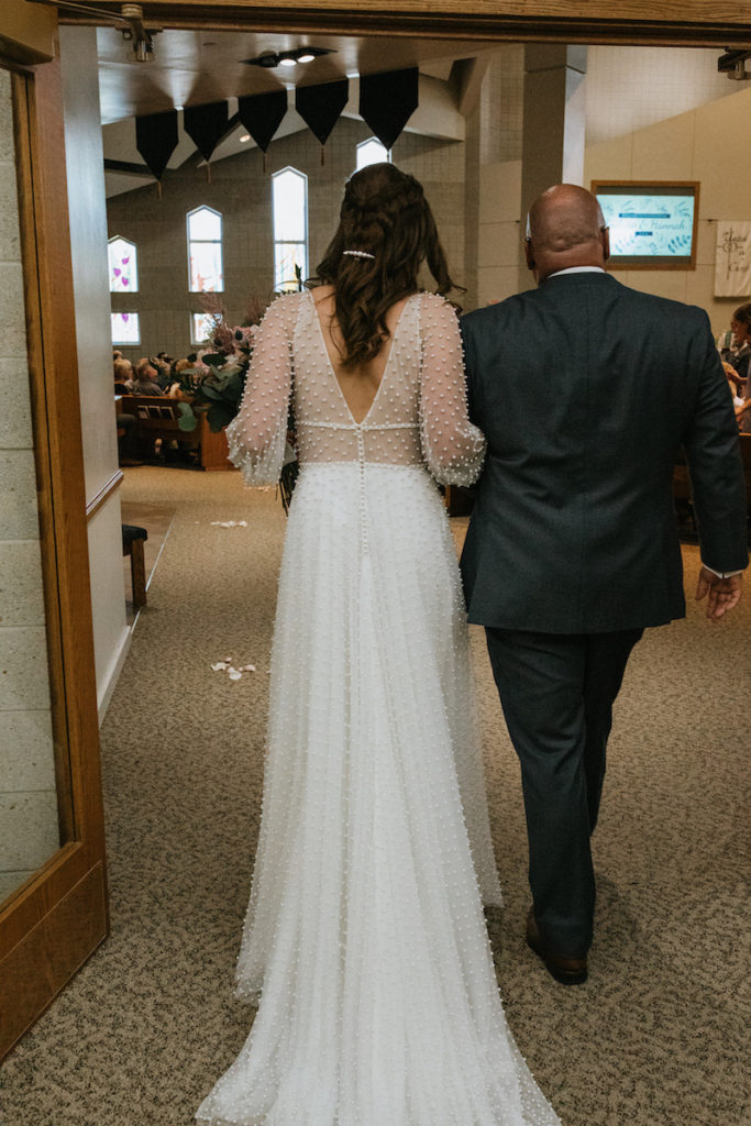 Bride walking down the aisle with her father at the St. Paul Lutheran Church in Iowa. 