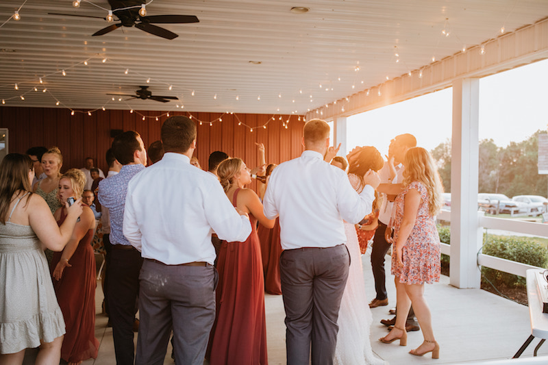 Guests dancing under a pavilion at a summer wedding reception in Iowa. 