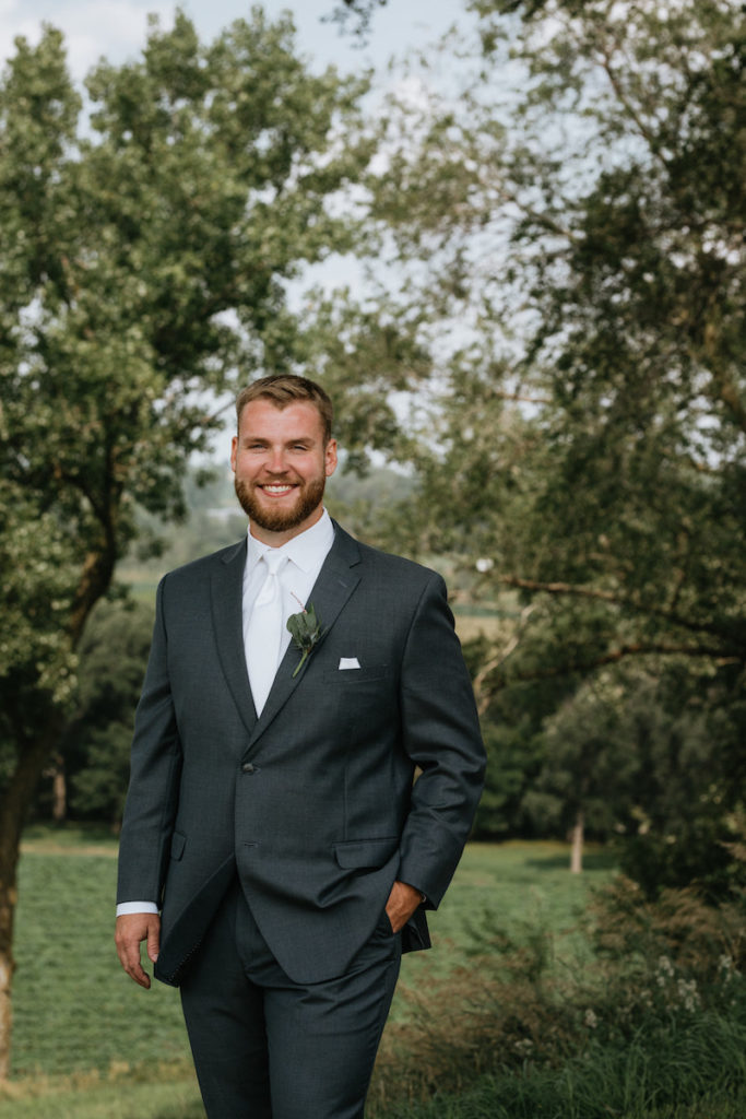 Groom portraits wearing a dark grey suit and white shirt and tie. 