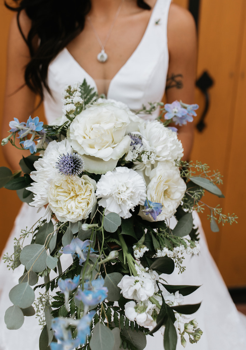 Oversized blue bridal bouquet and bride's intentional pendent necklace. 